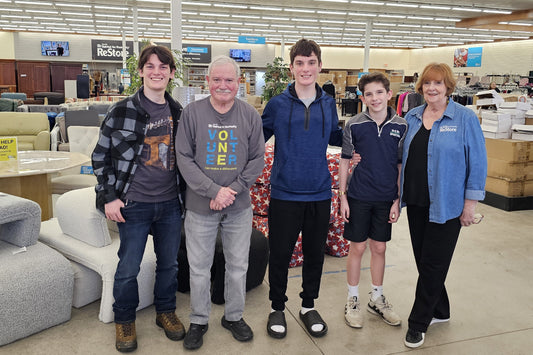 Volunteers inside Knoxville Habitat ReStore, with furniture and merchandise behind them